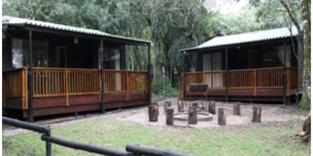 The Langebos Huts offer views of the forest and a communal braai area.