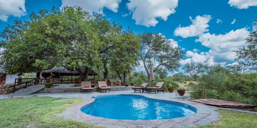 The swimming pool area of Ku Sungula Safari Lodge overlooks the dry riverbed and an active waterhole. 