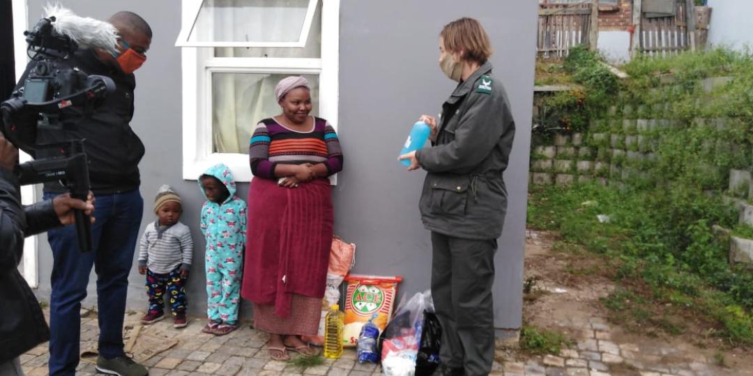 Deputy Mayor, Aubrey Tsengwa and Park Manager for Knysna, Megan Taplin, with the first recipient to receive groceries in Dam se Bos.