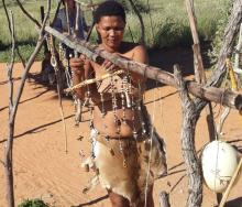 Khomani San woman creating beadwork using local materials. 